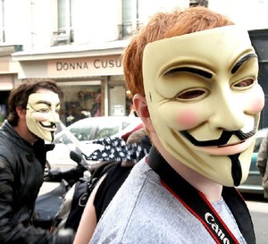 un chico con la máscara de v de vendetta durante una manifestación